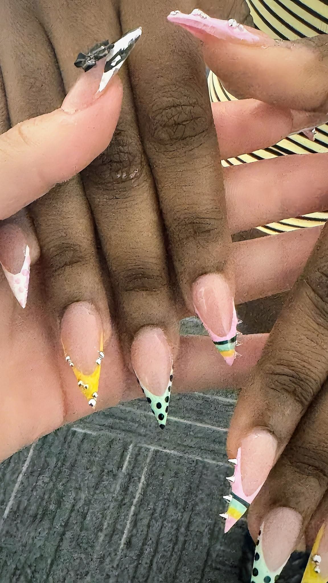 Pink stiletto set with polka dot tips, crystal accent nail, and a crown design